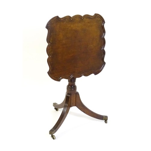 1432 - A late Georgian mahogany tripod table with a carved pie crust style top, a coil style turned pedesta... 