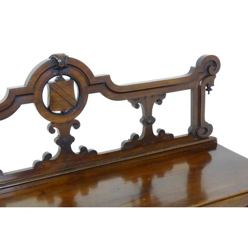 1439 - A Victorian mahogany bench, with a shaped top rail, carved terminals and an armorial shield to the c... 