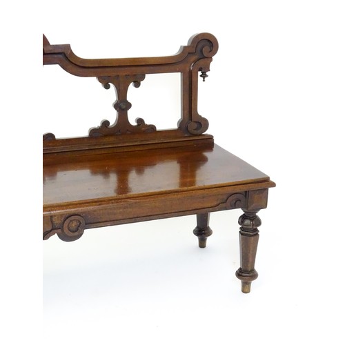 1439 - A Victorian mahogany bench, with a shaped top rail, carved terminals and an armorial shield to the c... 