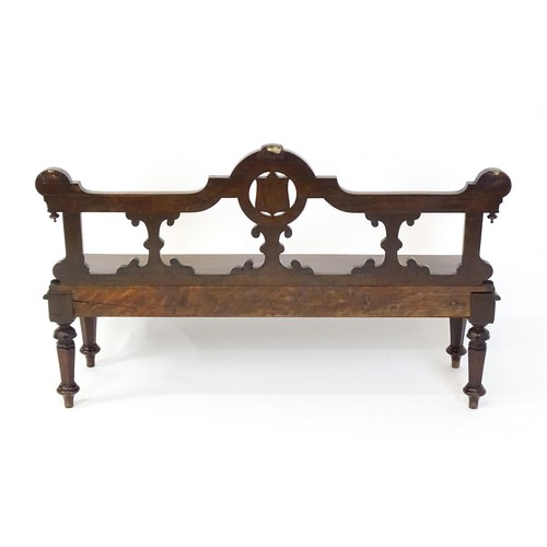 1439 - A Victorian mahogany bench, with a shaped top rail, carved terminals and an armorial shield to the c... 