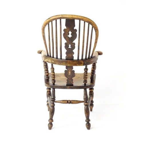 1453 - A mid 19thC Windsor chair with a double bow back, pierced back splat and swept arms above a shaped s... 