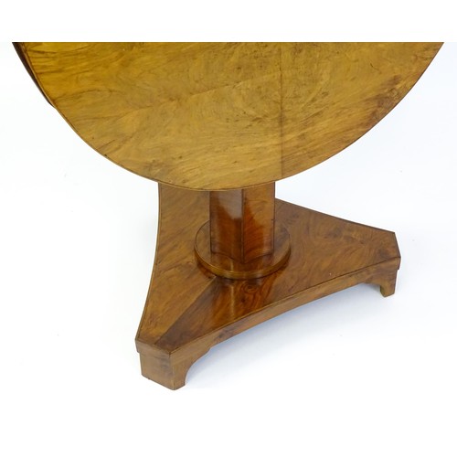 1472 - A 19thC walnut tilt top table of unusual proportions, with a circular table top above a canted pedes... 