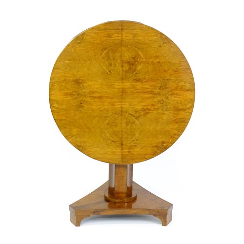 1472 - A 19thC walnut tilt top table of unusual proportions, with a circular table top above a canted pedes... 