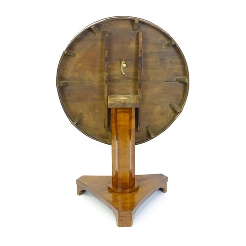 1472 - A 19thC walnut tilt top table of unusual proportions, with a circular table top above a canted pedes... 