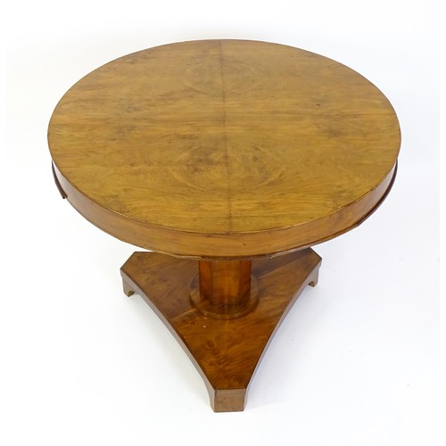 1472 - A 19thC walnut tilt top table of unusual proportions, with a circular table top above a canted pedes... 