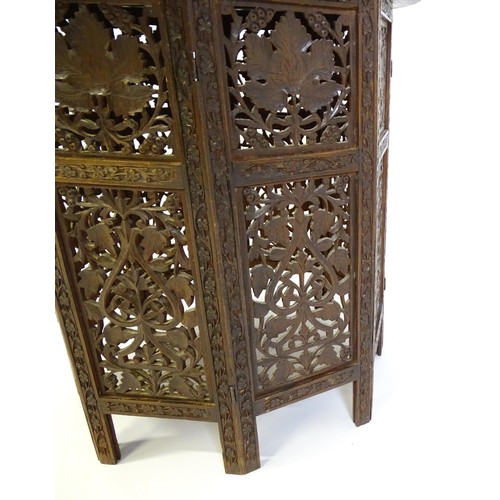 1474 - A late 19thC / early 20thC folding Islamic table with a floral carved top, brass inlay and the base ... 