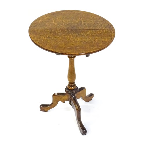 1475 - An early 20thC oak tripod table with a circular top above a turned tapering pedestal, a gadrooned lo... 