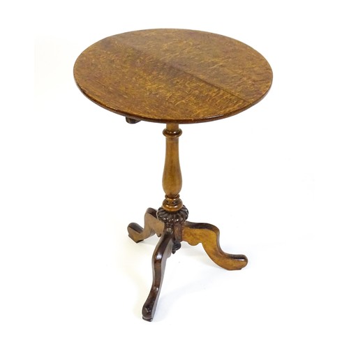 1475 - An early 20thC oak tripod table with a circular top above a turned tapering pedestal, a gadrooned lo... 