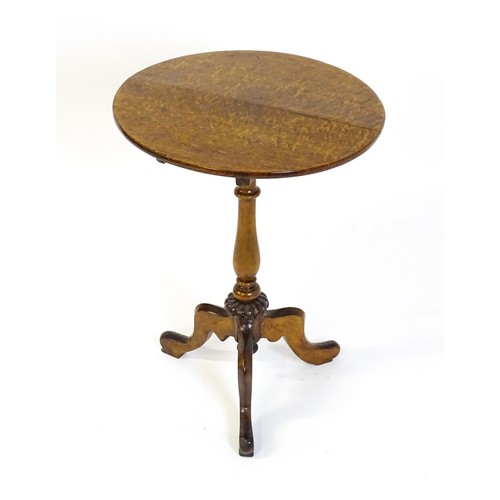 1475 - An early 20thC oak tripod table with a circular top above a turned tapering pedestal, a gadrooned lo... 