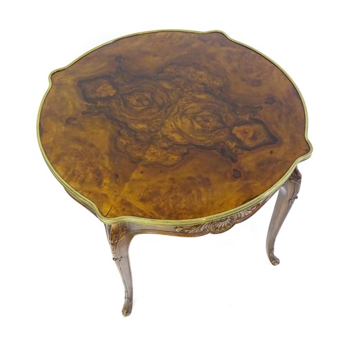 1477 - A late 19thC / early 20thC walnut centre table with a shaped top and a gilt surround, the table havi... 