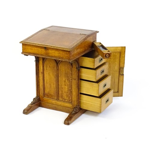 1480 - A 19thC oak Davenport with a leather inset writing slope above a panelled front and sides with Gothi... 