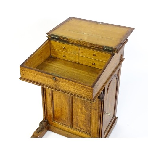 1480 - A 19thC oak Davenport with a leather inset writing slope above a panelled front and sides with Gothi... 