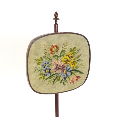 1489 - A mid 19thC rosewood pole screen, with an adjustable tapestry panel, a turned stem with coil detaili... 