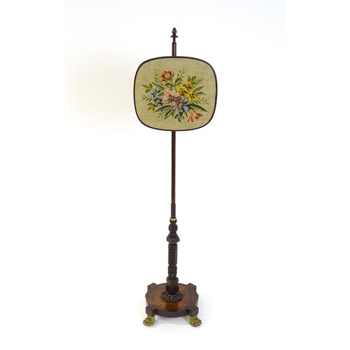 1489 - A mid 19thC rosewood pole screen, with an adjustable tapestry panel, a turned stem with coil detaili... 