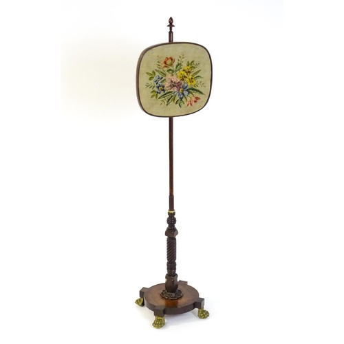 1489 - A mid 19thC rosewood pole screen, with an adjustable tapestry panel, a turned stem with coil detaili... 