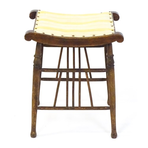 1494 - An early 20thC Aesthetic style stool in the Liberty style, with a concave top above four turned tape... 