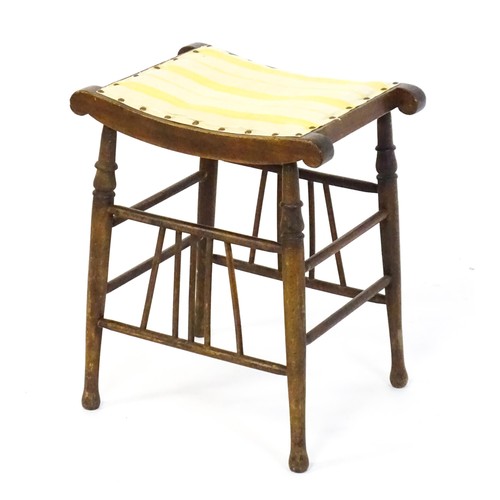 1494 - An early 20thC Aesthetic style stool in the Liberty style, with a concave top above four turned tape... 