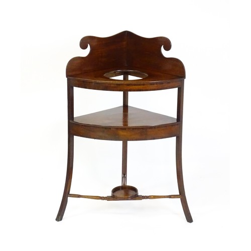 1496 - A 19thC mahogany corner washstand with an ogee shaped upstand, a circular recess to the top and two ... 