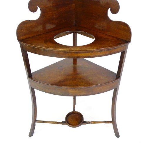 1496 - A 19thC mahogany corner washstand with an ogee shaped upstand, a circular recess to the top and two ... 