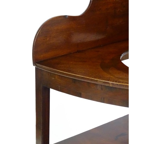 1496 - A 19thC mahogany corner washstand with an ogee shaped upstand, a circular recess to the top and two ... 