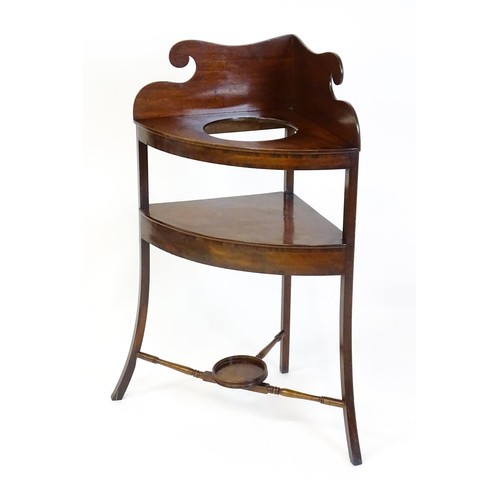 1496 - A 19thC mahogany corner washstand with an ogee shaped upstand, a circular recess to the top and two ... 