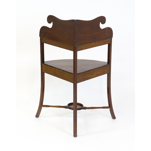 1496 - A 19thC mahogany corner washstand with an ogee shaped upstand, a circular recess to the top and two ... 