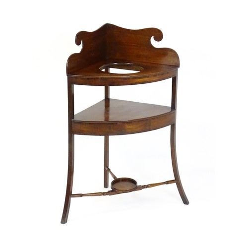 1496 - A 19thC mahogany corner washstand with an ogee shaped upstand, a circular recess to the top and two ... 