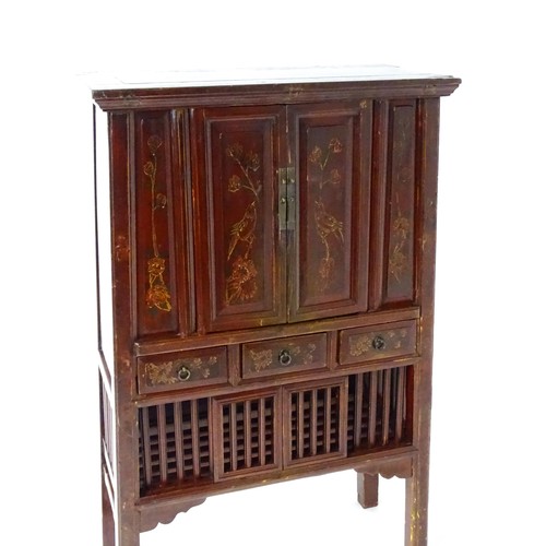 1505 - An early 20thC red lacquered Chinese cabinet with painted birds and flowers on the panelled front, d... 