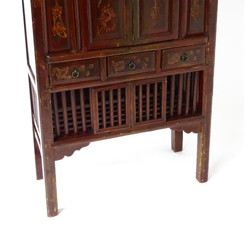 1505 - An early 20thC red lacquered Chinese cabinet with painted birds and flowers on the panelled front, d... 