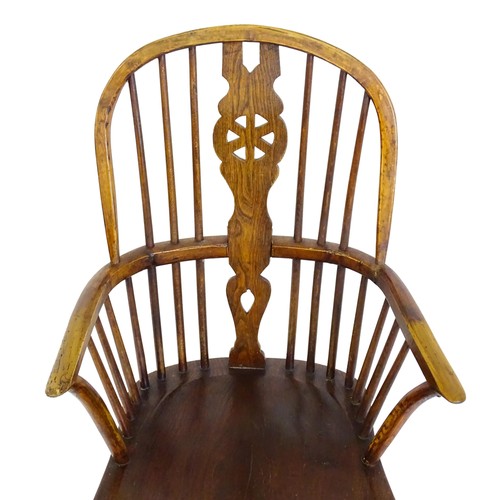 1517 - A 19thC double bow back Windsor chair with a pierced back splat, spindled backrest and a shaped seat... 