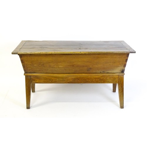 1521 - A late 19thC dough trough with a planked lid, exposed dovetailing to the frame and raised on four sp... 