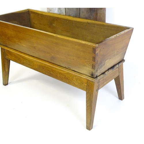 1521 - A late 19thC dough trough with a planked lid, exposed dovetailing to the frame and raised on four sp... 