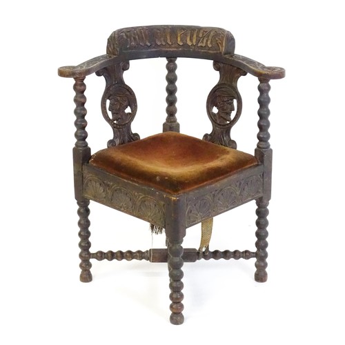 1522 - A late Georgian carved corner chair with inscribed Latin lettering, a drop in seat and raised on bob... 