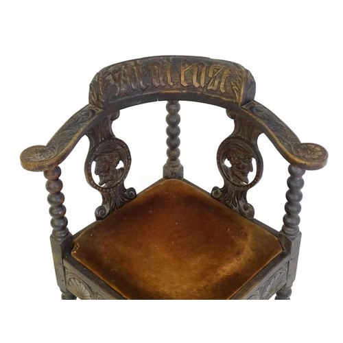 1522 - A late Georgian carved corner chair with inscribed Latin lettering, a drop in seat and raised on bob... 