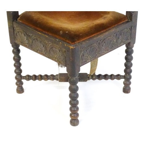 1522 - A late Georgian carved corner chair with inscribed Latin lettering, a drop in seat and raised on bob... 