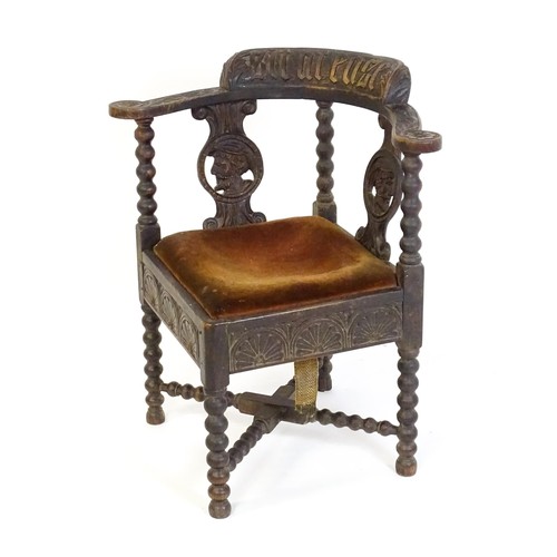 1522 - A late Georgian carved corner chair with inscribed Latin lettering, a drop in seat and raised on bob... 