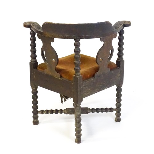 1522 - A late Georgian carved corner chair with inscribed Latin lettering, a drop in seat and raised on bob... 