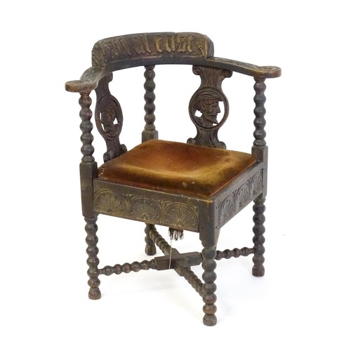 1522 - A late Georgian carved corner chair with inscribed Latin lettering, a drop in seat and raised on bob... 