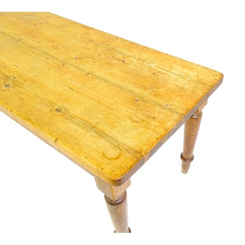 1524 - An Edwardian pine refectory / dining table  raised on four turned tapering legs. 72