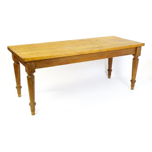 1524 - An Edwardian pine refectory / dining table  raised on four turned tapering legs. 72