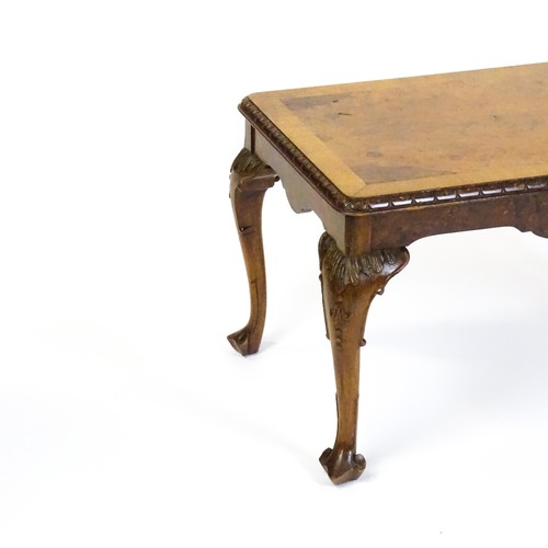 1530 - A mid / late 20thC coffee table with a burr walnut veneered top, with an egg and dart moulded edge a... 