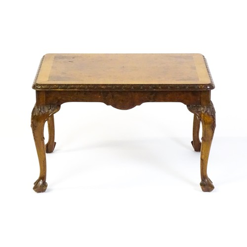 1530 - A mid / late 20thC coffee table with a burr walnut veneered top, with an egg and dart moulded edge a... 