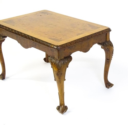 1530 - A mid / late 20thC coffee table with a burr walnut veneered top, with an egg and dart moulded edge a... 