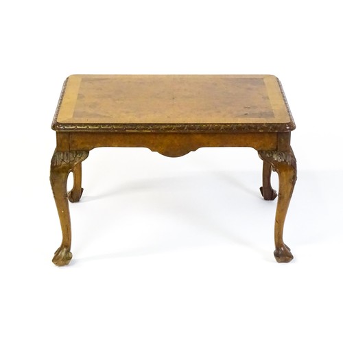 1530 - A mid / late 20thC coffee table with a burr walnut veneered top, with an egg and dart moulded edge a... 