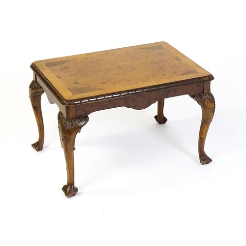 1530 - A mid / late 20thC coffee table with a burr walnut veneered top, with an egg and dart moulded edge a... 