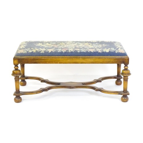 1534 - A William and Mary style long stool with a needlework drop in seat raised on turned tapering legs un... 