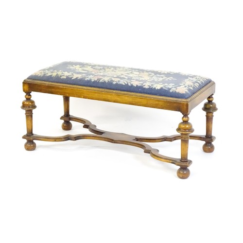 1534 - A William and Mary style long stool with a needlework drop in seat raised on turned tapering legs un... 