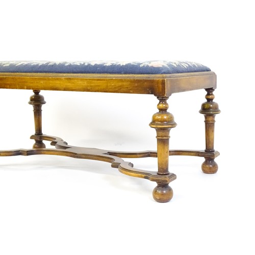 1534 - A William and Mary style long stool with a needlework drop in seat raised on turned tapering legs un... 