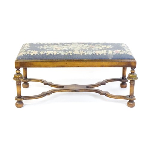 1534 - A William and Mary style long stool with a needlework drop in seat raised on turned tapering legs un... 