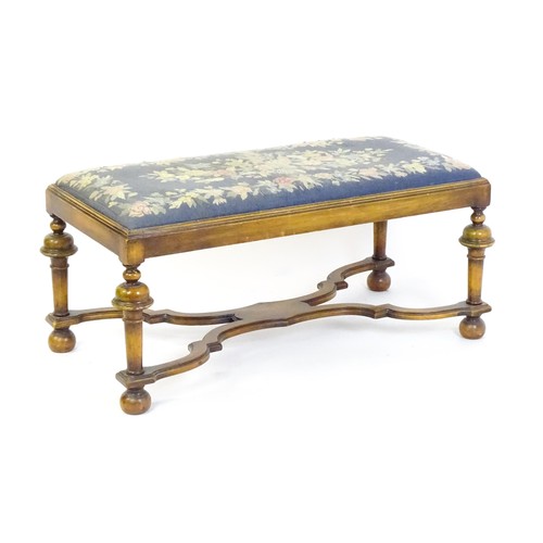 1534 - A William and Mary style long stool with a needlework drop in seat raised on turned tapering legs un... 